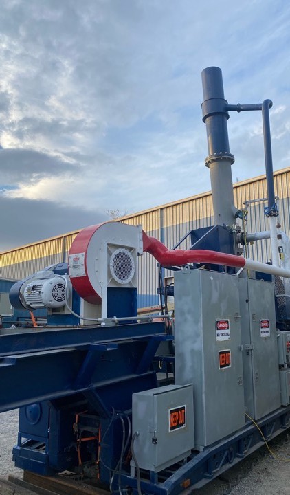 Close detail of WasteX gasifier blower and exhaust stack in the field