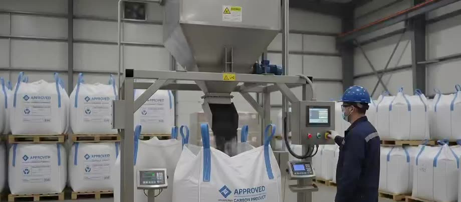 Operator monitoring finished biochar being packaged into bulk bags for shipment